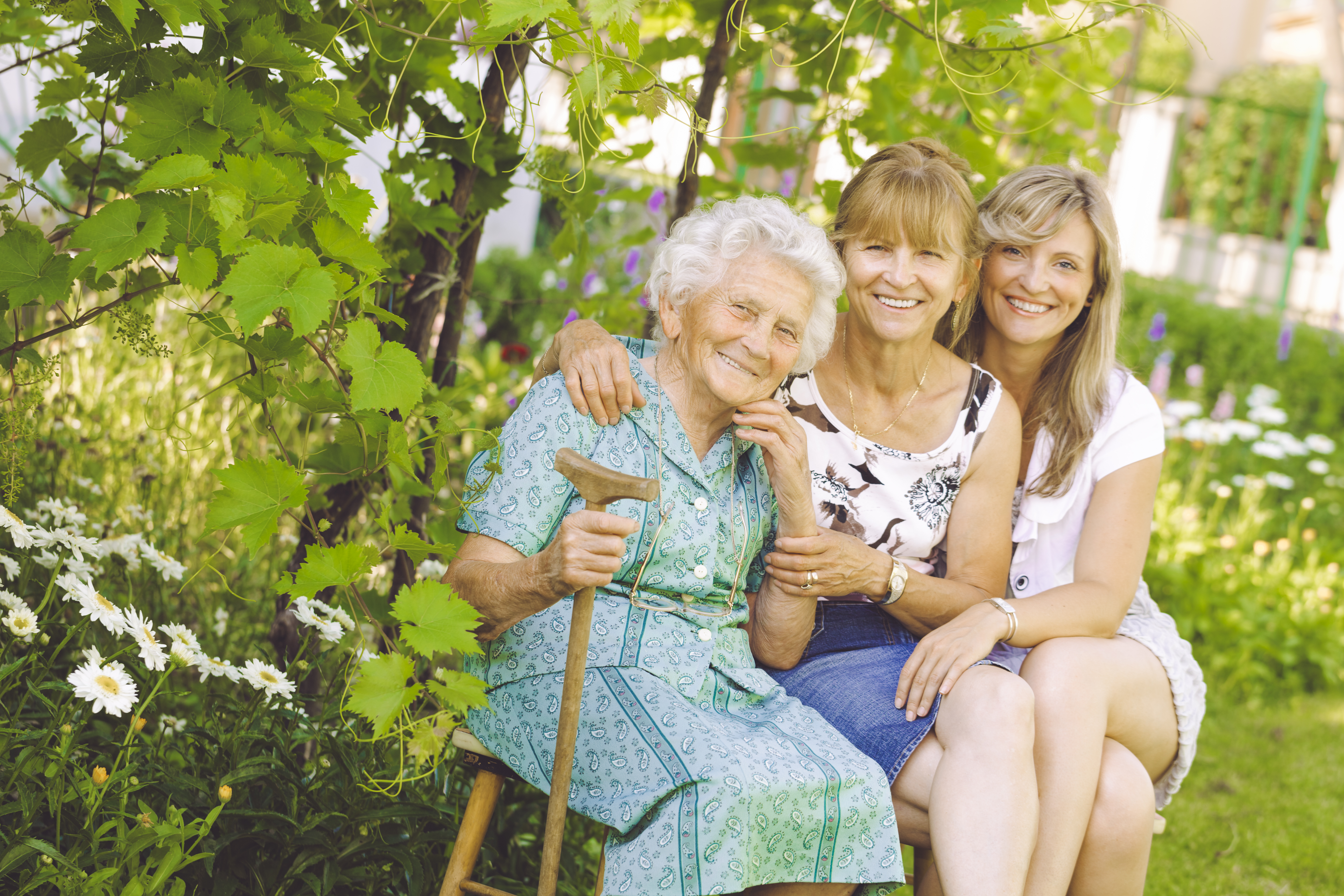 Frauen aus drei Generationen sitzen im Grünen